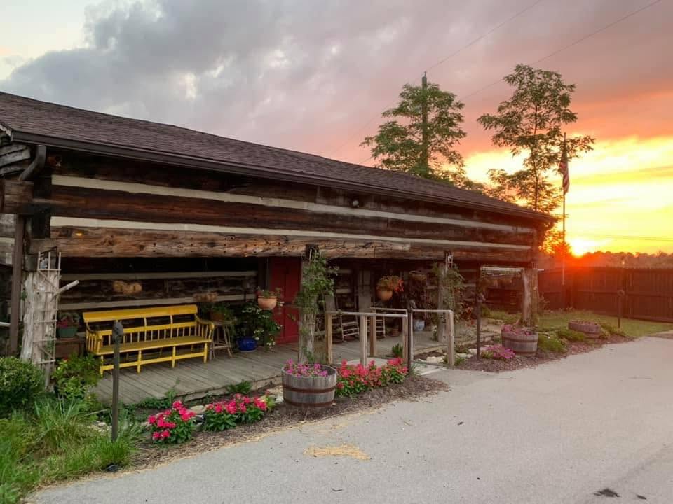 The Old Parsonage's log walls and welcoming front porch beneath a glowing evening sky
